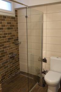 a bathroom with a toilet and a glass shower at Blue4Aqua Apartments in Kavála