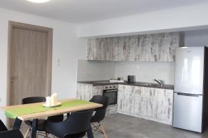a kitchen with a table and a refrigerator at Blue4Aqua Apartments in Kavála