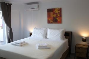 a bedroom with a bed with two towels on it at Blue4Aqua Apartments in Kavála