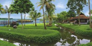 un complejo con un cuerpo de agua y palmeras en Kumarakom Lake Resort, en Kumarakom