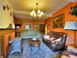 Very authentic Ardennes house في Paliseul: غرفة معيشة مع أريكة وطاولة