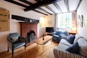 ein Wohnzimmer mit Couch und Kamin in der Unterkunft Pear Tree Cottage in Aldeburgh
