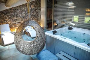 a large bath tub with a swing in a bathroom at Corte Grisela Wine&Relax in Monteforte dʼAlpone