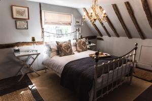 a bedroom with a bed and a chandelier at The Jasmine Room in Great Bentley