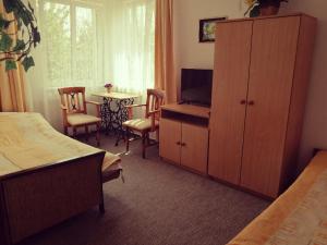 um quarto de hotel com um quarto com uma televisão e um armário em Pokoje na Ptasiej em Mikolajki