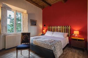 ein Schlafzimmer mit einem Bett und einer roten Wand in der Unterkunft Civicouno Campiglia in Campiglia Marittima