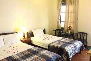 a hotel room with two beds with flowers on the sheets at Minh Kha Hotel in Mui Ne +101 photos