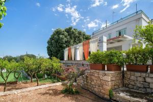 una casa con un muro di mantenimento e alcuni alberi di Amoredimare B&B in Villa a Polignano a Mare