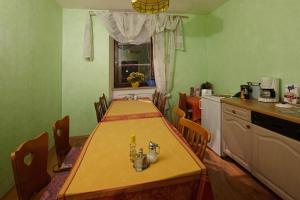 a kitchen with a table and chairs and a kitchen with a table and a counter at Pension Röhrig in Hirzenach