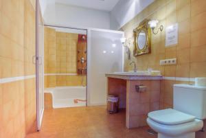 a bathroom with a toilet and a sink and a tub at Hostal Nuevo Milán I in San Clemente