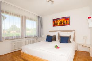ウールディンゲン・ミュールホーフェンにあるBodenseeDomizilの白いベッドルーム(青い枕の大きな白いベッド付)