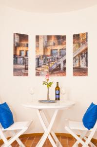 ウールディンゲン・ミュールホーフェンにあるBodenseeDomizilの白いテーブル(椅子2脚付)とワイン1本