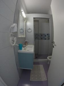 La salle de bains est pourvue d'un lavabo bleu et de toilettes. dans l'établissement Eleni Boutique Apartment, à Lindos