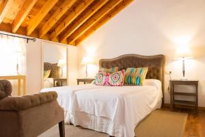 ein Schlafzimmer mit einem großen Bett mit Kissen darauf in der Unterkunft Hotel Cortijo del Arte - Caminito del Rey in Pizarra