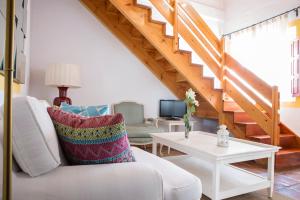 ein Wohnzimmer mit einer weißen Couch und einer Treppe in der Unterkunft Hotel Cortijo del Arte - Caminito del Rey in Pizarra