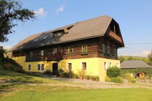 a large wooden house with a black roof at Urlaub am Zechnerhof in Straßburg in Kärnten