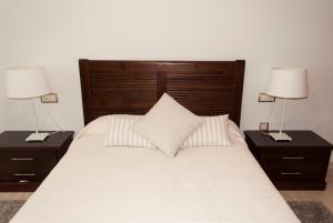 a bedroom with a bed with two nightstands and two lamps at Apartamento céntrico con parking privado in Córdoba