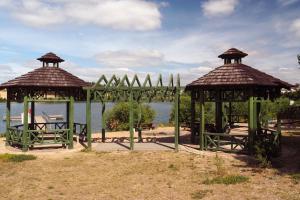 zwei Pavillons in einem Park neben dem Wasser in der Unterkunft Domek na Kaszubach - Cały dla Ciebie! in Lipnica