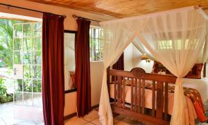 a bedroom with a bed with a canopy at Kasane Self Catering in Kasane