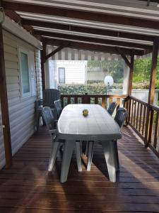 a table on a deck with chairs on a porch at Mobilhome a Gastes in Gastes