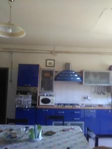 a kitchen with blue cabinets and a table in it at Forte Colorado in Noto
