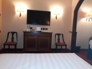 a bedroom with a bed and two chairs and a flat screen tv at Hotel Motel Luna in Segrate