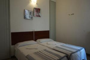 una camera con due letti e due quadri appesi al muro di Hostal Sant Carlo a Barcellona