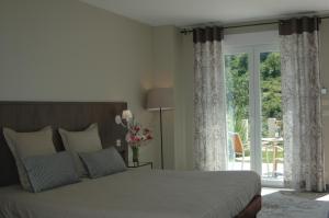 a bedroom with a bed and a sliding glass door at Les Jardins de Soulane B&B - Adults only in Belcastel-et-Buc +50 photos