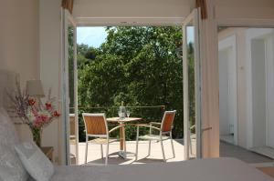 a bedroom with a balcony with a table and chairs at Les Jardins de Soulane B&B - Adults only in Belcastel-et-Buc