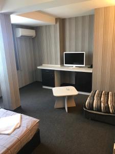 Zimmer mit einem Schreibtisch, einem Computer und einem Bett in der Unterkunft Casa Blanca in Sofia