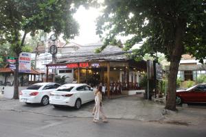 una mujer caminando por la calle delante de una tienda en Minh Kha Hotel en Mui Ne