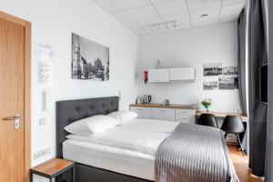 a bedroom with a bed and a desk with chairs at Piano Apartments in Kaunas