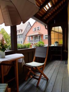 einen Stuhl auf einer Veranda mit einem Tisch und einem Fenster in der Unterkunft Lindes Ferienwohnung in Dinkelsbühl