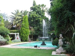 a fountain in the middle of a swimming pool at Villa Victoria executive Guest House in Benoni
