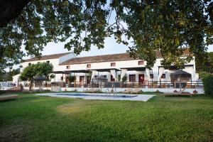 ein Gebäude mit einem Pool vor einem Hof in der Unterkunft Hotel Cortijo del Arte - Caminito del Rey in Pizarra