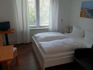 a bedroom with a white bed and a window at Budget in Westerland (Sylt)