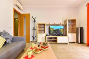 a living room with a couch and a television at Beach House Adelfas San Agustín MCI in San Agustin