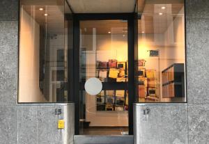 a glass door of a building with books in it at Apartment with free covered parking - City Center in Ghent