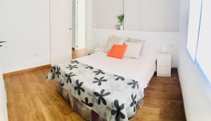 マラガにあるBeachside City Centre Apartmentの小さなベッドルーム(オレンジ色の枕付きのベッド付)
