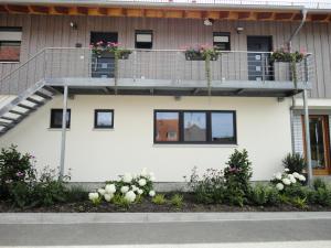 a white building with a balcony and flowers at Gasthof Reiterstuben in Hoßkirch