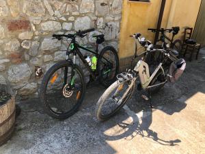Dos bicicletas están estacionadas junto a una pared de piedra. en Agriturismo Ilardo en Collesano