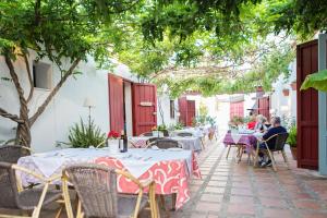 an outdoor patio with tables and chairs and trees at Hotel Cortijo del Arte - Caminito del Rey in Pizarra