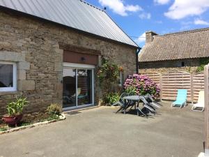 een terras met een tafel en stoelen voor een gebouw bij Ar baradoz in Guiler-sur-Goyen