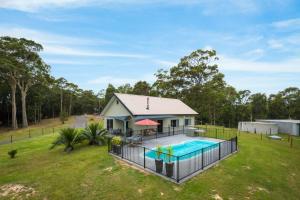 an aerial view of a house with a swimming pool at Bush Retreat With Private Pool in Narooma