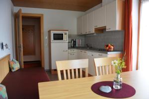 eine Küche mit einem Tisch und einer Blumenvase darauf in der Unterkunft Hotel Garni Alpina in Damüls