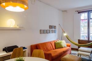 バルセロナにあるGreat apartment in Poblesecのリビングルーム(オレンジ色のソファ、テーブル付)
