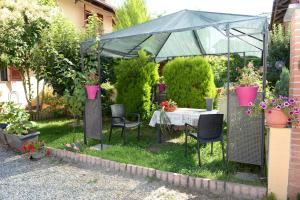 un jardín con mesa y sillas en un invernadero en La Valle B&B, en Asti