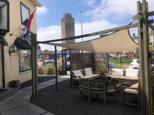 a patio with a hammock and chairs and a building at Hotel Anna in Zandvoort