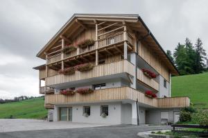 a building with flower boxes on the side of it at Ciasa de Lenz in San Cassiano