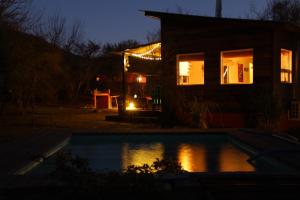 una casa con piscina por la noche en Samsara Traslasierra en Los Hornillos